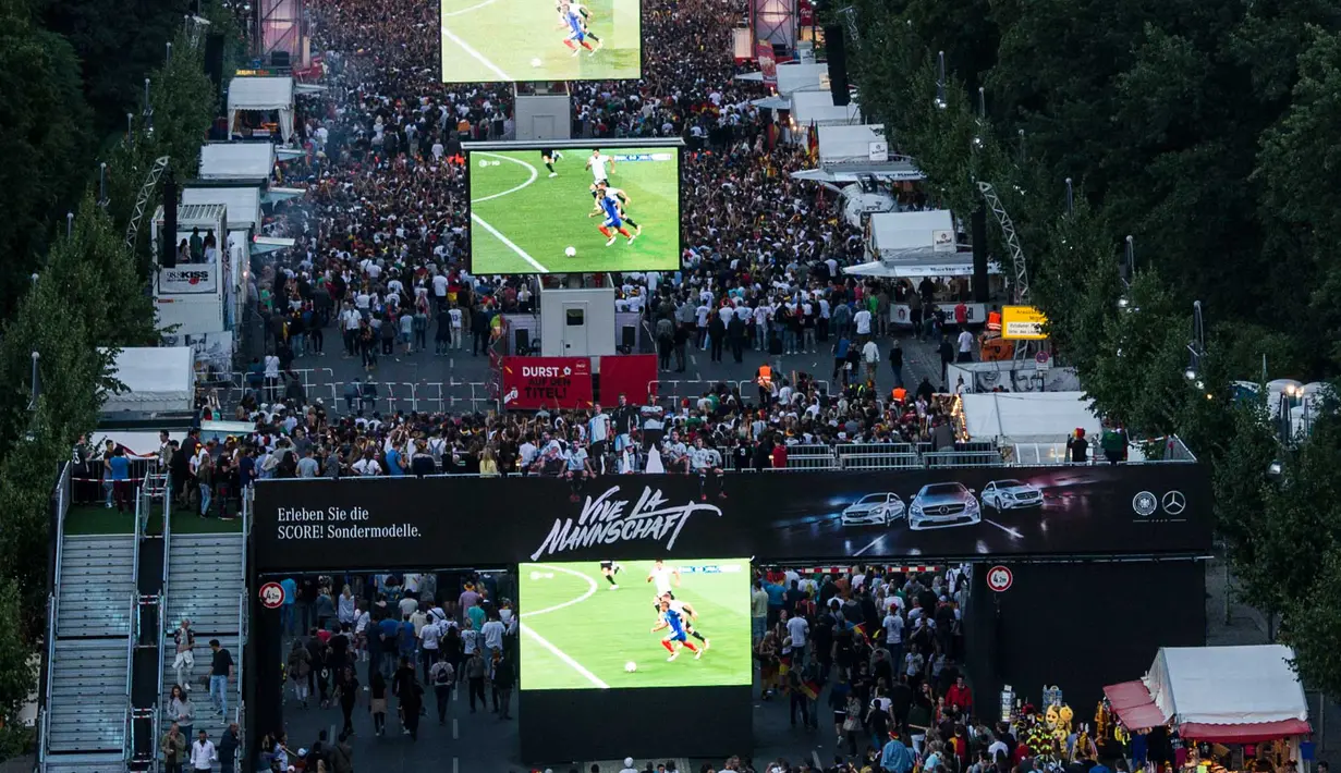 Suporter menonton laga semifinal piala eropa 2016 antara Prancis melawan Jerman lewat layar raksasa di Brandenburg Gate, Berlin, Jerman, (07/7/2016). (EPA/Paul Zinken)