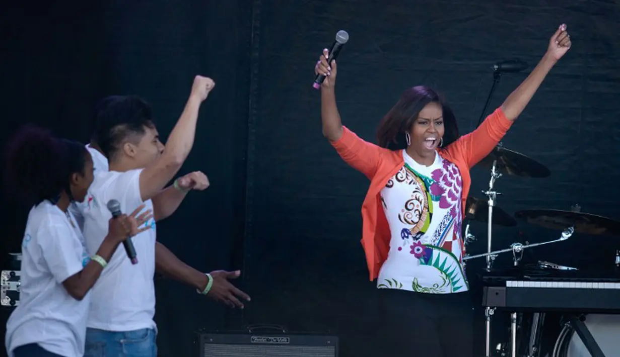 Ibu negara Amerika Serikat, Michelle Obama bersama para penari ikut memeriahkan acara Easter Egg Roll yang diadakan di Gedung Putih, Senin (6/4/2015). (AFP PHOTO/Brendan SMIALOWSKI)