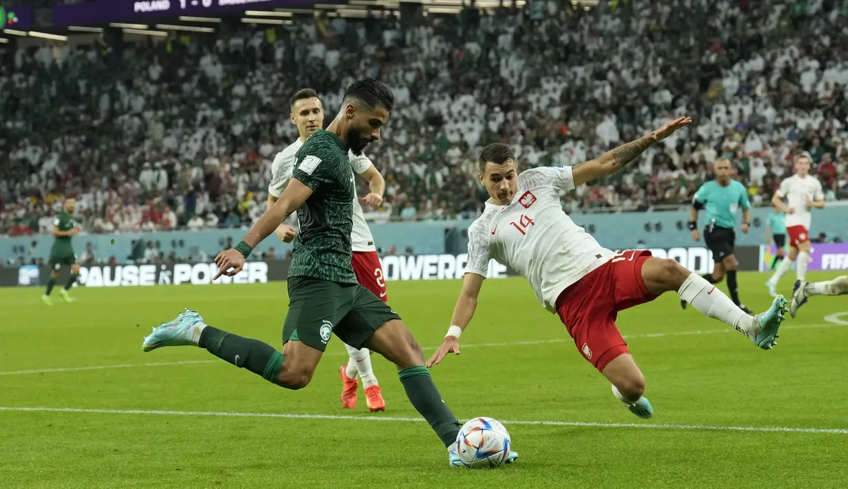 <p>Penyerang Arab Saudi, Saleh Al-Shehri, berusaha mengumpan bola dari kawalan pemain Polandia, Jakub Kiwior, selama pertandingan grup C Piala Dunia 2022 Qatar di Education City Stadium di Al Rayyan, Qatar, Sabtu (26/11/2022). Arab Saudi, meski kalah, masih di peringkat dua dengan tiga poin. (AP Photo/Francisco Seco)</p>