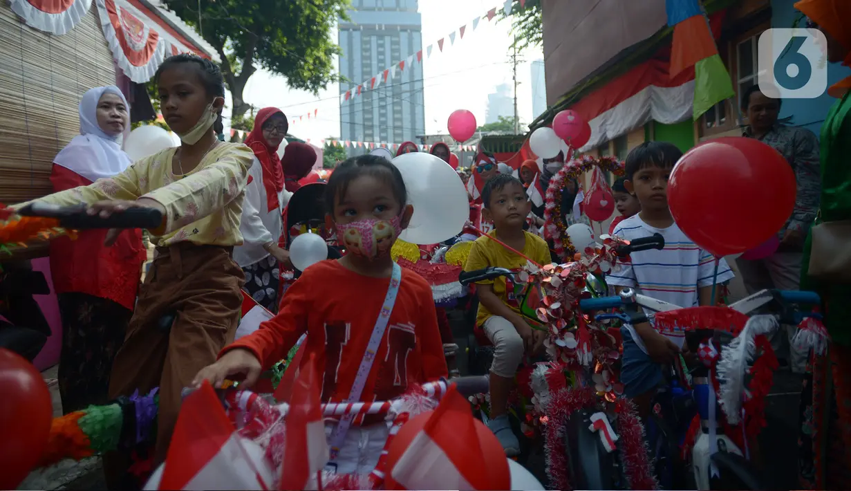 Anak-anak RW 04 Kebun Melati mengikuti karnaval sepeda hias saat pelaksanaan upacara Hari Ulang Tahun ke-77 Republik Indonesia di Jakarta, Rabu (17/8/2022). Peringatan Hari Ulang Tahun Republik Indonesia telah menjadi tradisi di kampung tersebut sejak tahun 1975. (merdeka.com/Imam Buhori)