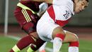 Gelandang Peru, Joel Sanchez (depan) berusaha mengontrol bola dari hadangan pemain Venezuela Gabriel Cichero saat pertandingan Copa Amerika 2015 di Estadio Elías Figueroa, Chile, Kamis (18/6/2015). Peru menang 1-0 atas Venezuela. (REUTERS/David Mercado)