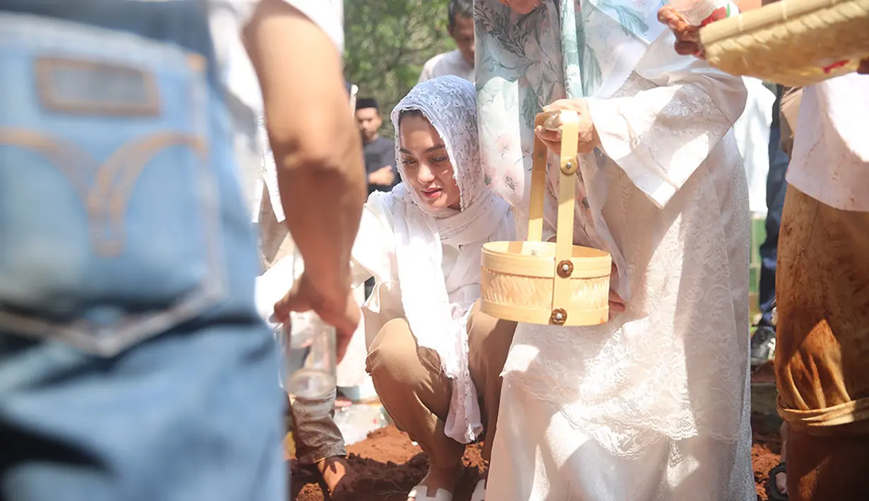 Saat prosesi pemakaman, Ibnu Jamil juga ikut turun ke liang lahat menguburkan sang ayah. Pria berusia 42 tahun itu tampak melantunkan iqamah sebelum jenazah di urug tanah merah. [Foto; Adrian Putra/Fimela.com]