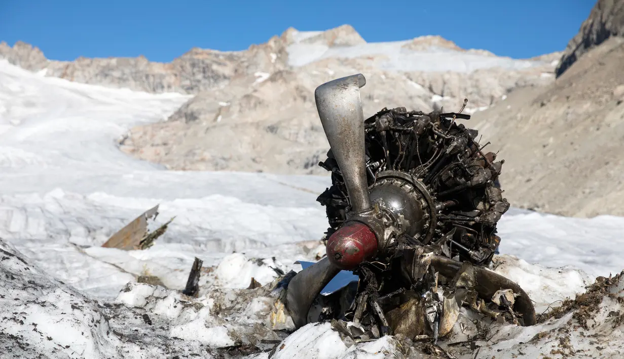 Mesin pesawat tempur Perang Dunia II milik AS saat ditemukan di Gauli Glacier, di Bernese Alps, Swiss (17/9). Pesawat Perang Dunia II C-53 Skytrooper Dakota tersebut jatuh tahun 1946. (Peter Klaunzer/Keystone via AP)