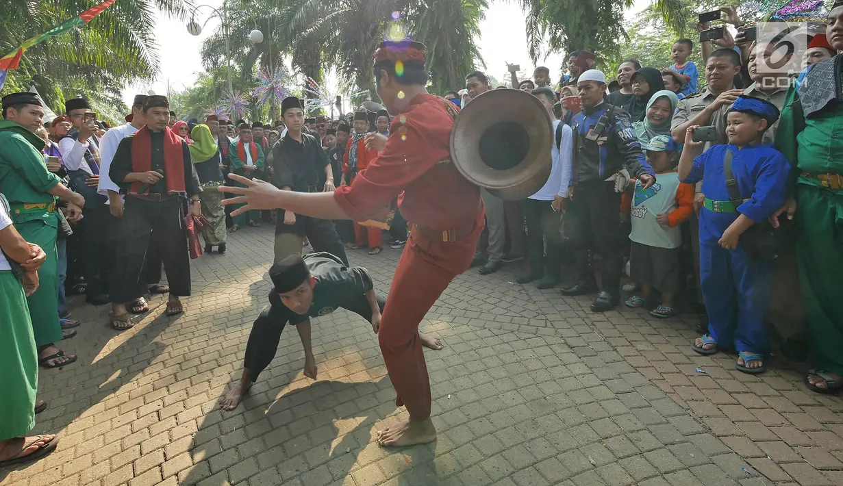 Warga menampilkan silat palang pintu saat Lebaran Orang Depok di Sawangan, Depok, Jawa Barat, Minggu (7/7/2019). Lebaran Orang Depok baru pertama kali diadakan acara tersebut untuk melestarrikan budaya dan sebagai ajang silaturahmi warga Depok. (Liputna6.com/Herman Zakharia)