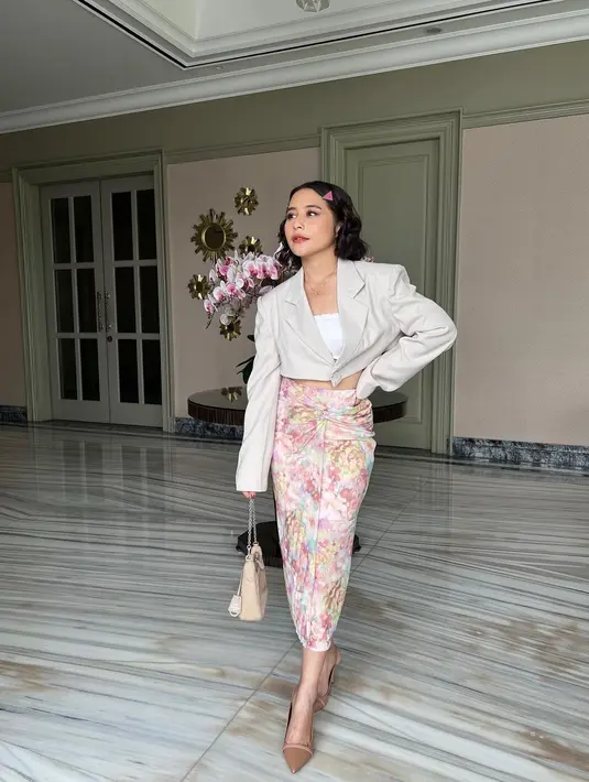 Prilly kembali memadukan penampilannya dengan blazer dan batik. Ia mengenakan cropped putih dengan cropped blazer berwarna cokelat muda, dipadukan mengenakan kain batik bernuansa merah muda sebagai rok. [Foto: Instagram/prillylatuconsina96]