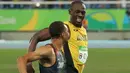  Pelari Asal Jamaika, Usain Bolt tersenyum dengan Andre de Grasse, pelari Kanada saat bersaing di semifinal lari 200 meter pria di Rio de Janeiro, Brasil (17/8). Usain Bolt meraih medali emas kedua di lari 200 meter pria. (REUTERS/Gonzalo Fuentes)