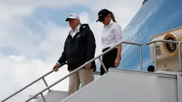 Presiden AS, Donald Trump dan Ibu Negara Melania Trump turun dari pesawat kepresidenan di Bandara Internasional Austin, Texas, Selasa (29/8). Trump mencoba menyemangati warganya lewat kunjungan ke Texas yang dihantam badai Harvey. (AP Photo/Evan Vucci)