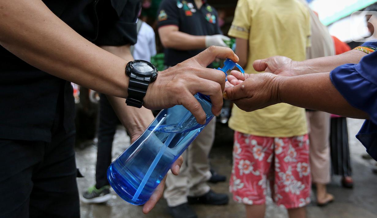 Warga membersihkan tangan menggunakan hand sanitizer saat antre Operasi Pasar di Pasar Palmerah, Jakarta, Jumat (20/3/2020). Di tengah merebaknya virus corona Perum Bulog menggelar Operasi Pasar untuk mencegah panic buying dengan harga murah. (Liputan6.com/Fery Pradolo)