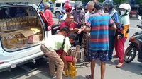 Anggota DPRD Tuban Rasmani berkeliling ke sejumlah lokasi mendistribusikan minyak goreng dengan harga murah. (Adirin/Liputan6.com)
