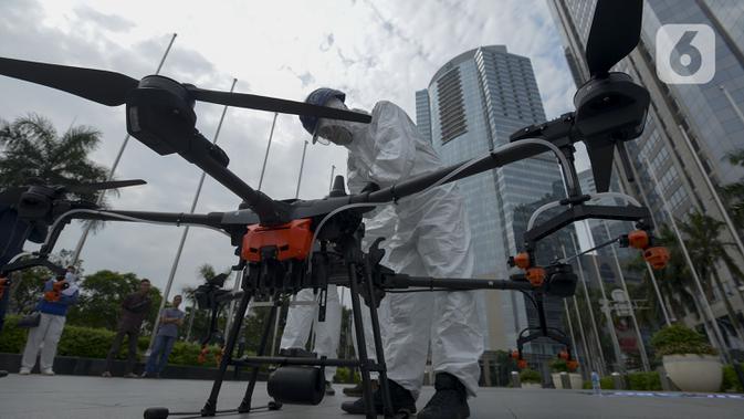 Petugas menyiapkan drone untuk menyemprotkan cairan disinfektan di Jalan Bursa Efek menuju Patung  Pemuda, Jakarta, Jumat (27/3/2020). Penyemprotan dilakukan untuk mencegah penyebaran virus corona COVID-19. (merdeka.com/Imam Buhori)