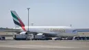 Mobil dan petugas kesehatan mengepung pesawat setelah penumpang Emirates Airline dilaporkan sakit di Bandara Kennedy New York, Rabu (5/9). Belum ada keterangan resmi tentang penyakit yang dikeluhkan penumpang serta awak pesawat itu. (AP/Bebeto Matthews)