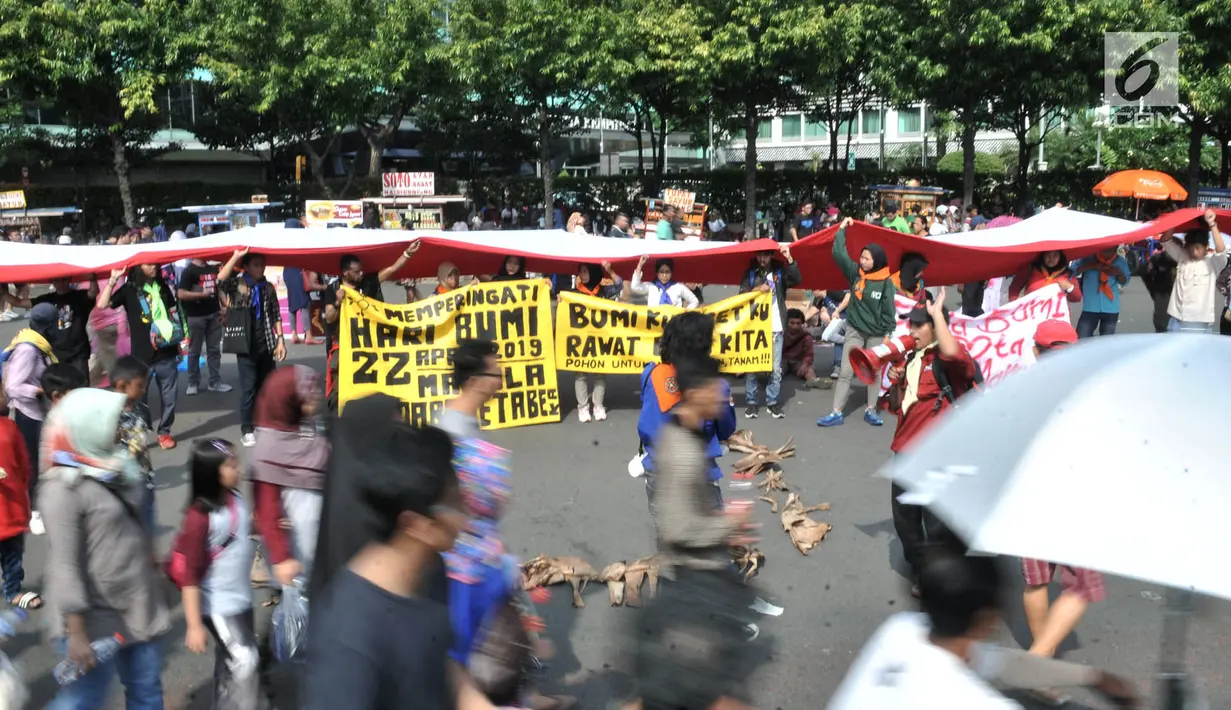 Komunitas Mahasiswa Pecinta Alam (Mapala) se-Jabodetabeka membentangkan bendera Merah Putih raksasa saat memperingati Hari Bumi di CFD Bundaran HI, Jakarta, Minggu (21/4). Aksi ini sekaligus mengajak masyarakat untuk lebih peduli terhadap lingkungan. (merdeka.com/Iqbal Nugroho)