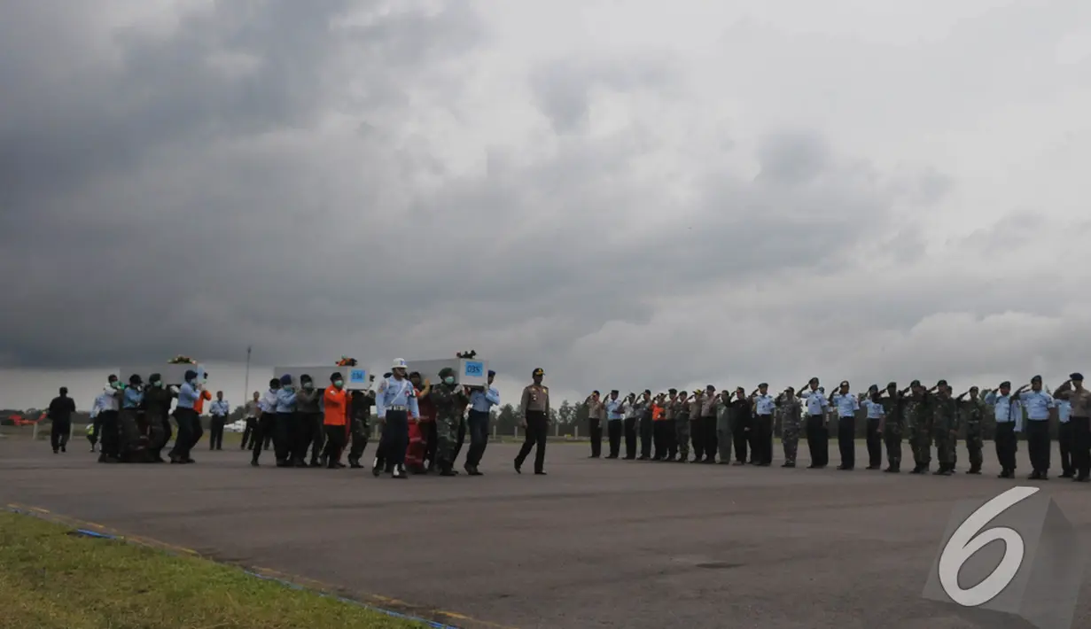 Sejumlah petugas berbaris di sisi landasan saat menyambut jenazah penumpang AirAsia QZ8501, Pangkalan Bun, Kalteng, Senin (5/1/2015). (Liputan6.com/Herman Zakharia)