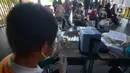 Petugas kesehatan menyiapkan vaksin dosis ketiga (Booster) di RPTRA Kopi Gandaria, Pasar Rebo, Jakarta, Jumat (15/7/2022). Wajibnya vaksin booster terkait terus bertambahnya kasus Covid-19 yakni 3.584 orang pada hari Kamis 14 Juli 2022. (merdeka.com/Imam Buhori)