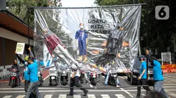 Aktivis lingkungan membawa boneka menyeberangi jalan saat akan melakukan demonstrasi di depan Balai Kota DKI Jakarta, Jumat (16/9/2022). Aksi tersebut memperingati satu tahun kemenangan warga negara untuk hak udara bersih. Meski telah menang, menurut mereka belum ada satu pun putusan hakim yang dijalankan para tergugat. (Liputan6.com/Faizal Fanani)