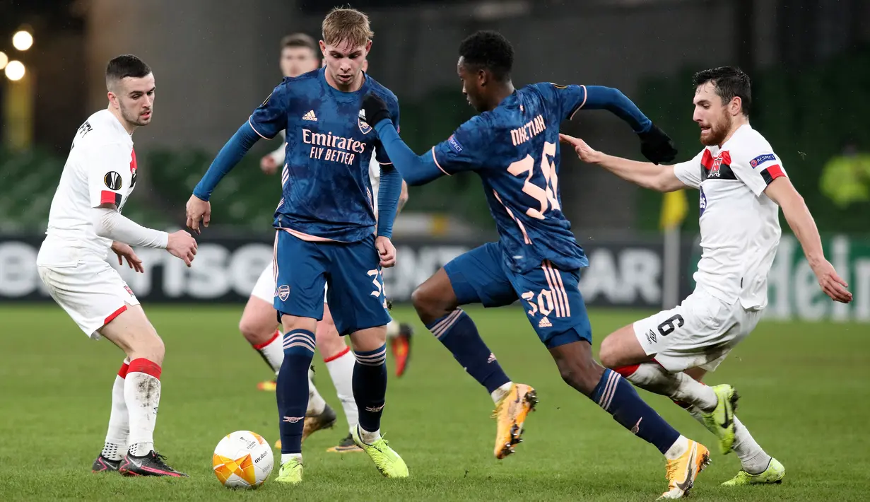 Striker Arsenal, Eddie Nketiah (kedua kanan) bersaing dengan gelandang Dundalk, Jordan Flores (kanan) pada pertandingan Grup B Liga Europa 2020/2021 di Stadion Aviva, Jumat (11/12/2020) dini hari WIB. Arsenal menang 4-2 saat bertandang di markas wakil Irlandia, Dundalk. (Paul Faith / AFP)