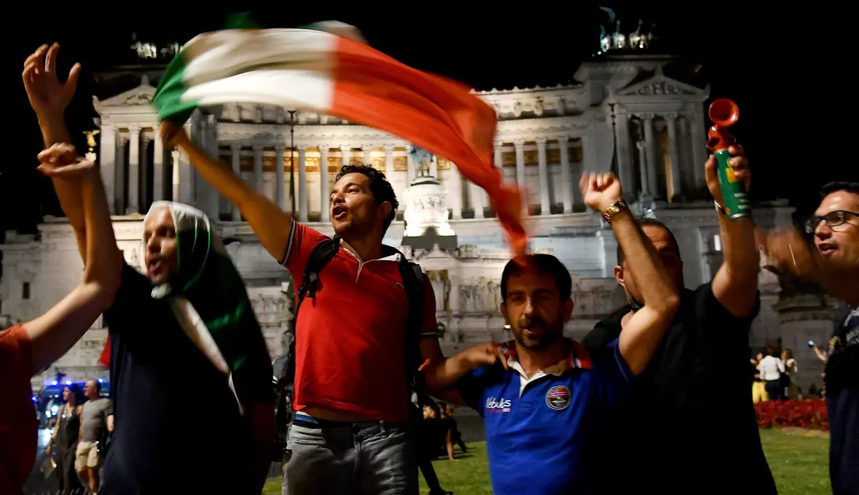 Suporter Italia merayakan kemenangan atas Spanyol pada pertandingan semifinal Euro 2020 di Piazza Venezia, di Roma tengah, Rabu (7/7/2021). Italia akan bertemu antara pemenang Inggris vs Denmark di babak final. (AFP Photo/Isabella BONOTTO)