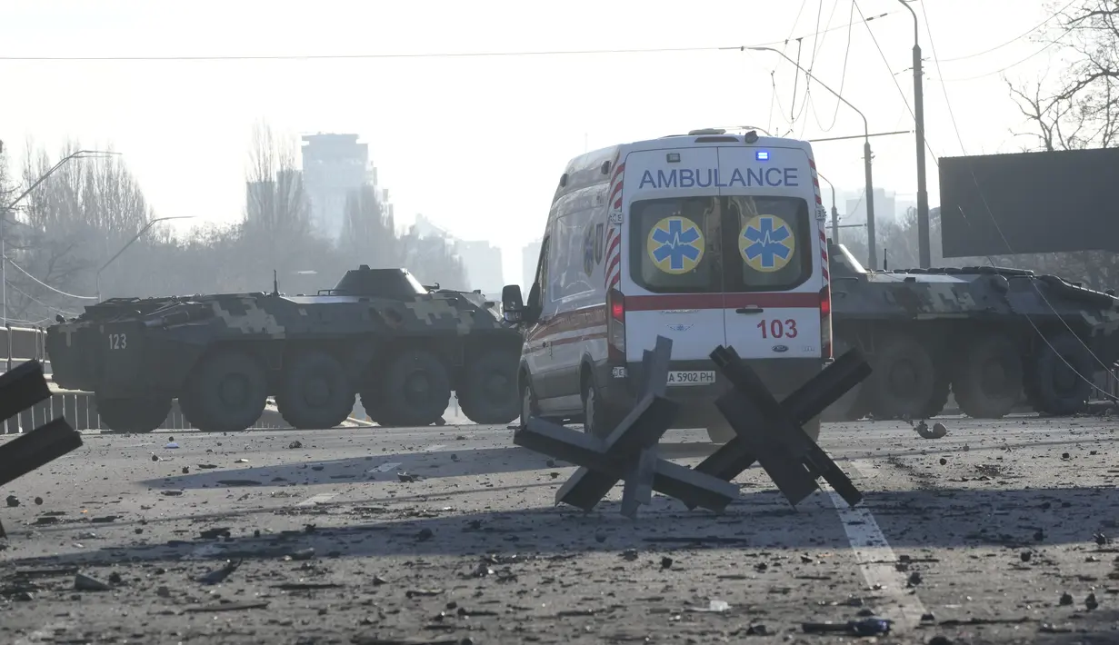 Sebuah ambulans diparkir di dekat barikade dan kendaraan lapis baja Ukraina di Kiev, Ukraina, Sabtu (26/2/2022). Pasukan Rusia menyerbu ke arah ibu kota Ukraina pada Sabtu (26/2), dan pertempuran jalanan pecah saat pejabat kota mendesak penduduk untuk berlindung. (AP Photo/Efrem Lukatsky)
