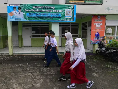 Murid tingkat Sekolah Menengah Pertama (SMP) dalam program Rintisan Sekolah Swasta Gratis sesaat sebelum belajar dalam kelas pada kegiatan Masa Pengenalan Lingkungan Sekolah (MPLS) di SMP Tarbiyah Islamiyah, Depok, Jawa Barat, Senin (14/7/2025). (merdeka.com/Arie Basuki)