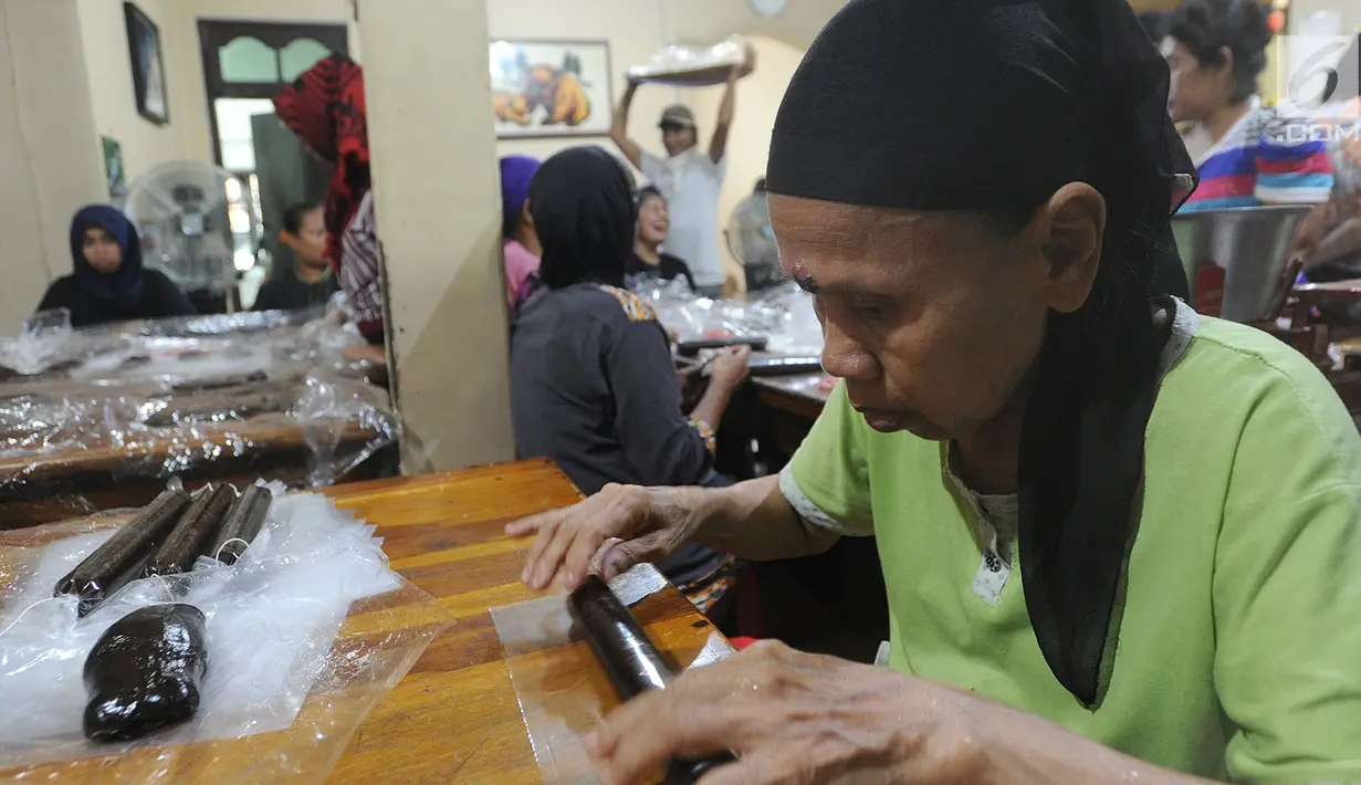 Pekerja mengemas dodol keranjang di pabrik Ny Lauw, Neglasari, Tangerang, Banten, Minggu (27/1). Menjelang Imlek, tingkat pesanan dodol mengalami peningkatan hingga tiga kali lipat dari biasanya. (Merdeka.com/Arie Basuki)