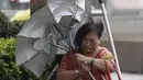 Seorang wanita berusaha melewati angin kencang dari Topan Matmo yang melanda Taiwan, Rabu (23/7/14). (REUTERS/Pichi Chuang)