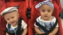 Topi dan bandana pita menjadi ciri khas dari Tatjana dan Bima. Wajah polos mereka begitu menggemaskan saat duduk di stroller merah mereka. (Intagram/tatjanadanbima)
