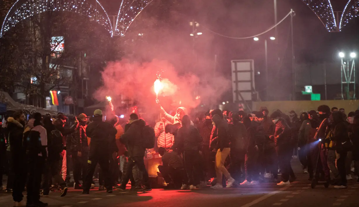 Pendukung Maroko menyalakan api di jalan setelah timnas kesayangan mereka kalah dari Prancis pada laga semifinal Piala Dunia 2022, di Brussel, Belgia, Rabu (14/12/2022). Polisi anti huru-hara menembakkan gas air mata agar kerusuhan tersebut bisa mereda. (Simon Wohlfahrt / AFP)