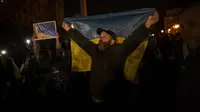 Warga Ukraina berkumpul di Kyiv tengah untuk merayakan perebutan kembali Kota Kherson, Ukraina, Jumat, 11 November 2022 setelah pasukan Rusia mundur. (AP Photo/Bernat Armangue)