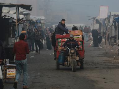 Seorang pria mengemudikan kendaraan saat pagi hari yang diselimuti kabut di Khan Yunis, Jalur Gaza utara pada Jumat 17 Januari 2025. (Bashar TALEB/AFP)