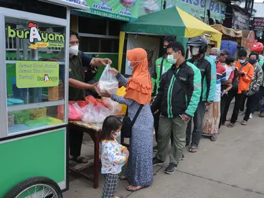 Warga mengantre untuk mendapatkan bubur gratis di kawasan  pintu keluar tol Kukusan Depok, Jawa Barat, Kamis (20/1/20222). Sudah hampir lima bulan ini, setiap pagi pukul 07.30  dibagikan sekitar 100 porsi bubur kepada warga. (merdeka.com/Arie Basuki)