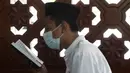 Seorang siswa mengenakan masker untuk membantu mengekang penyebaran COVID-19 saat membaca kitab suci Alquran di Masjid Attaqwa, Bekasi, Jawa Barat, Selasa (4/5/2021). Selama Ramadhan, umat muslim menahan diri dari makan, minum, merokok dan seks dari subuh hingga maghrib. (AP Photo/Achmad Ibrahim)