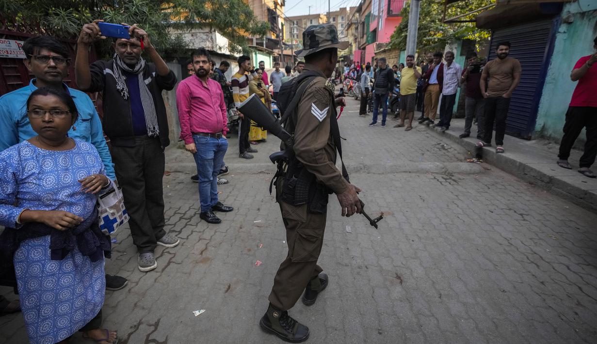 Anak tersebut segera membunyikan alarm dan orang-orang dari lingkungan sekitar keluar, yang membuat macan tutul ketakutan dan berlari ke dalam gedung. (AP Photo/Anupam Nath)