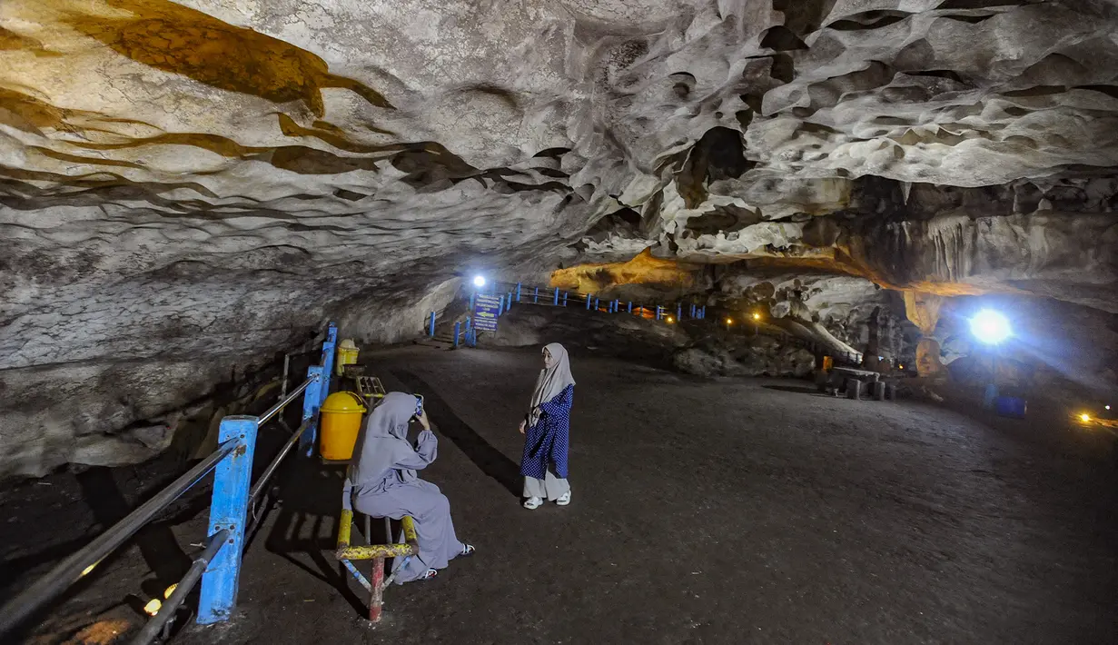 Daya tarik utama Goa Lowo terletak pada ruang-ruang luas menyerupai aula raksasa dengan langit-langit mencapai 20 hingga 50 meter. Tampak dalam foto, aktivitas pengunjung di dalam Goa Lowo di Watuagung, Trenggalek, Jawa Timur. (merdeka.com/Arie Basuki)