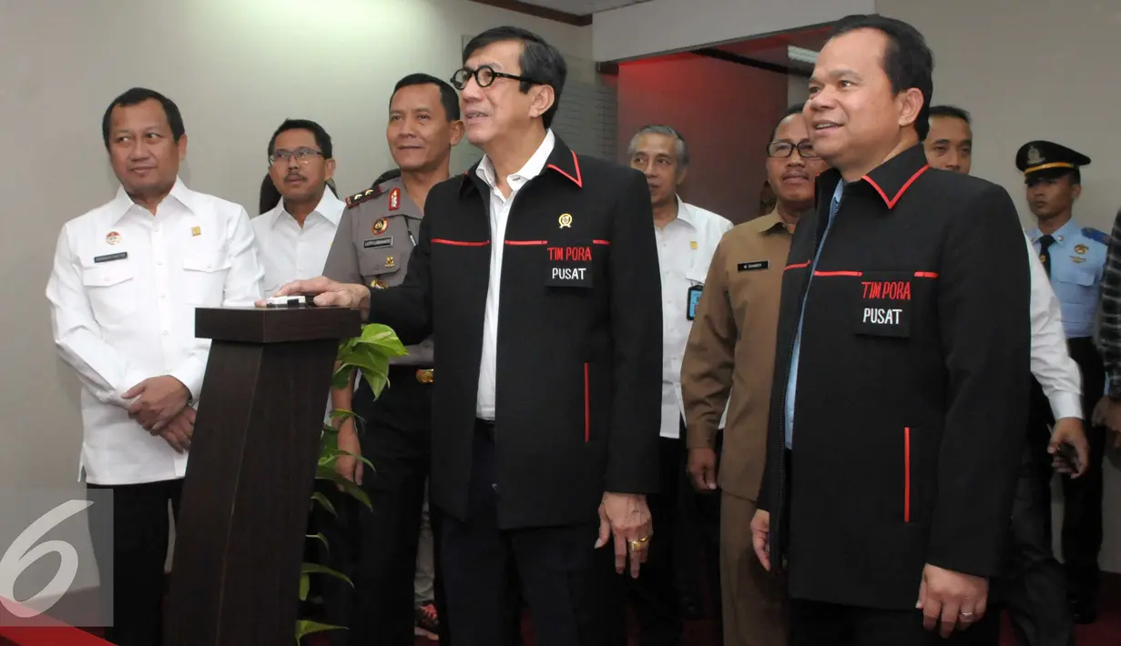 Menkumham Yasonna Laoly menekan tombol saat meresmikan tim Pengawasan Orang Asing  (PORA) di Gedung Imigrasi Kemenkumham, Jakarta (8/4). Yasonna menekankan, tim PORA harus bekerja optimal menangani masalah warga negara asing. (Liputan.com/Helmi Afandi)