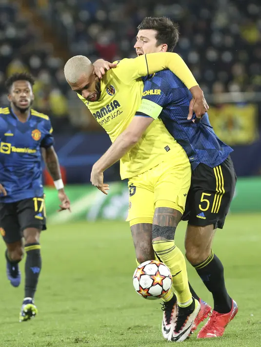 Gelandang Villarreal Etienne Capoue berebut bola dengan bek Manchester United (MU) Harry Maguire pada matchday kelima Grup F Liga Champions di Ceramica stadium, Rabu (24/11/2021) dini hari WIB. MU sukses meraih kemenangan 2-0 di kandang Villarreal. (AP Photo/Alberto Saiz)
