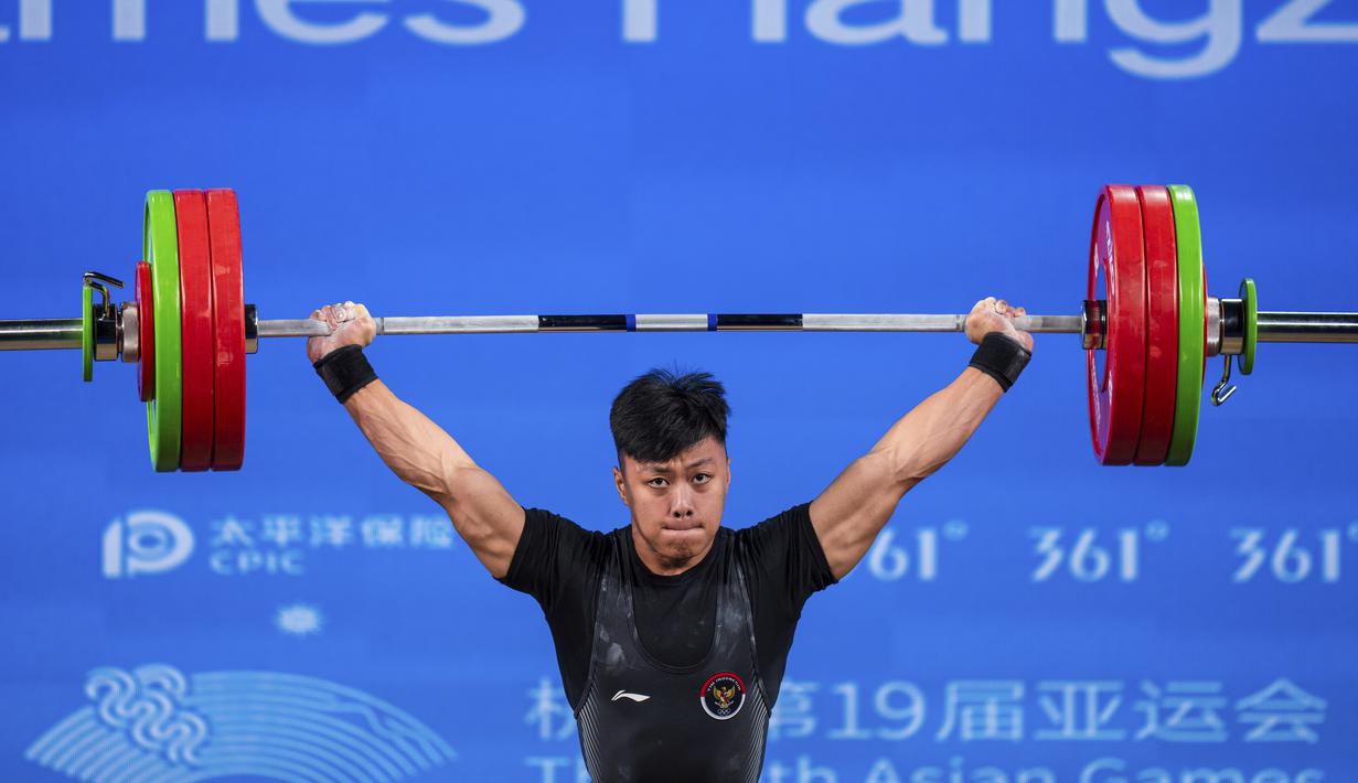 Lifter putra Indonesia, Rahmat Erwin Abdullah, saat beraksi di final 73 kilogram cabang angkat besi  Asian Games 2022 di Xiaoshan Sports Centre Gymnasium, Hangzhou, China, Selasa (3/10/2023). Total Rahmat Erwin mengumpulkan total angkatan 359kg. Torehan itu jadi rekor baru di Asian Games. (AP Photo/Louise Delmotte)