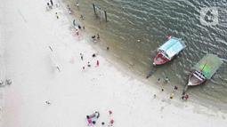 Pemandangan udara warga berlibur di Pantai Ancol, Pademangan, Jakarta Utara, Rabu (1/6/2022). Libur Nasional Hari Lahir Pancasila, dimanfaatkan warga mengajak sanak saudara tamasya di Pantai Ancol. (Liputan6.com/Herman Zakharia)