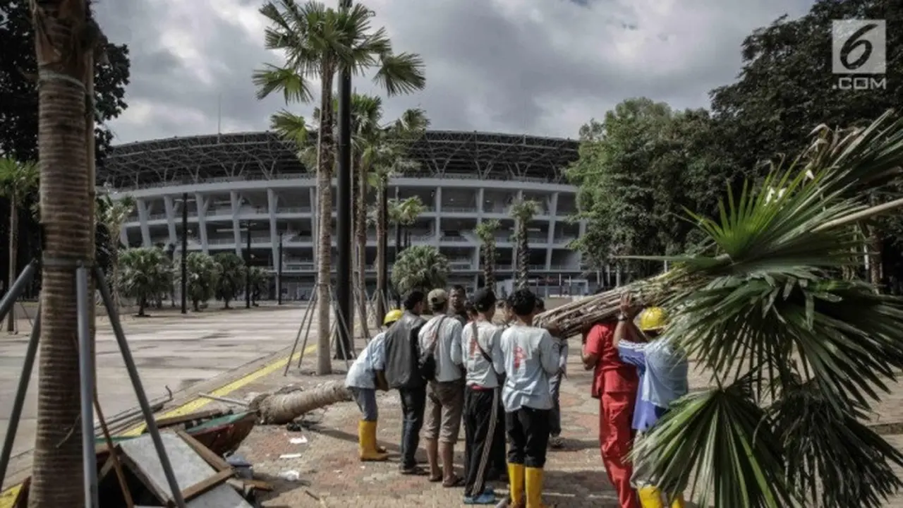 Petugas menumbangkan pohon yang rusak akibat ulah oknum suporter yang menyaksikan laga Final Piala Presiden 2018 di Stadion Utama GBK, Jakarta, Minggu (18/2) (Liputan6.com/Faizal Fanani)