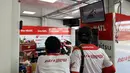 Dua orang mekanik Astra Honda Racing Team (AHRT) menyaksikan rekaman balapan dari televisi di sela mempersiapkan motor pembalapnya yang akan bertarung di balapan hari kedua ARRC Mandalika 2023 di Sirkuit Mandalika, Lombok, Sabtu (12/8/2023). (Bola.com/Iqri Widya)