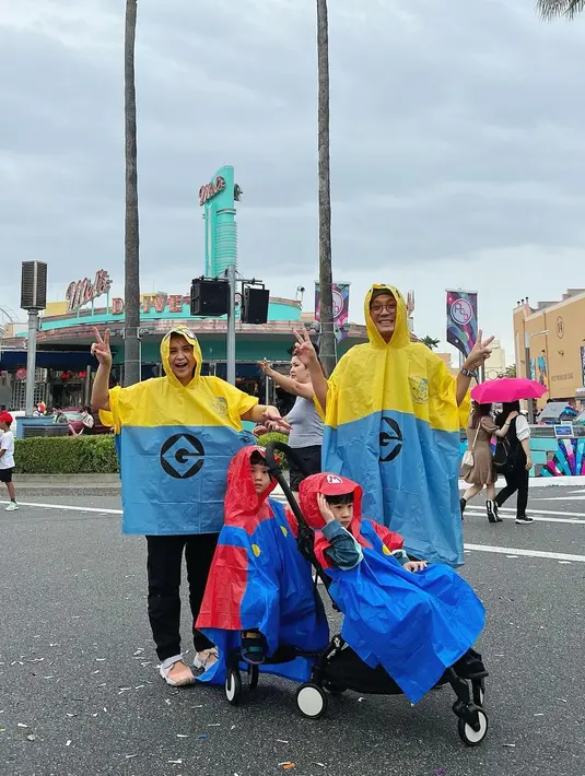 Kekompakan keluarga Junior Liem dan Putri Titian mengenakan jas hujan. Junior juga menceritakan bersama anak-anak menggunakan jas hujan, payung hingga naik turun kereta. [Instagram/putrititian]