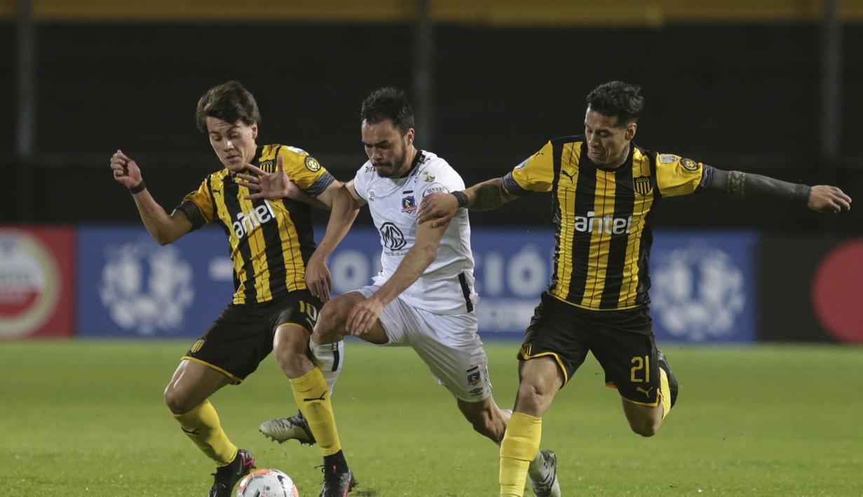 Gelandang Penarol, Facundo Pellistri (kiri) berusaha merebut bola gelandang Colo Colo Chili Gabriel Suazo (tengah) pada pertandingan fase grup Copa Libertadores di Stadion Campeon del Siglo di Banados de Carrasco, Departemen Montevideo, Uruguay, pada 29 September 2020. (AFP/Matilde Campodonico)