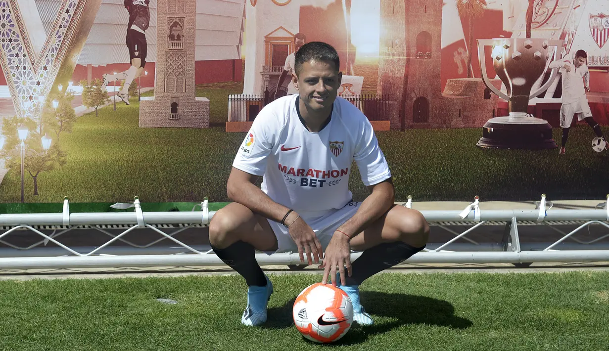 Penyerang baru Sevilla, Javier Hernandez 'Chicharito' berpose dengan jersey klub barunya selama presentasi resminya di Sport City of Sevilla (2/9/2019). Eks penyerang Manchester United dan Real Madrid ini digaet Sevilla dengan mahar yang dikabarkan mencapai 8 juta euro. (AFP Photo/Cristina Quicler)