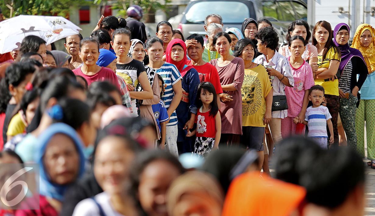 Warga mengantre untuk mendapatkan minyak goreng murah yang didistribusikan oleh Sinar Mas pada acara Bazar Rakyat di Rusun Marunda, Jakarta Utara, Kamis (30/6). (Liputan6.com/Angga Yuniar)
