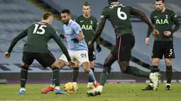 Gelandang Manchester City, Riyad Mahrez (kedua kiri) berusaha melewati para pemain Tottenham Hotspur pada pertandingan lanjutan Liga Inggris di Stadion Etihad, Manchester, Inggris, Minggu (14/2/2021). Man City masih memuncaki klasemen sementara Liga Inggris dengan 50 poin. (AP Photo/Rui Vieira)