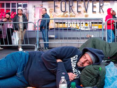 Para aktivis menghadiri acara "tidur bersama" di Times Square, New York City, pada 16 November 2023. (KENA BETANCUR/AFP)