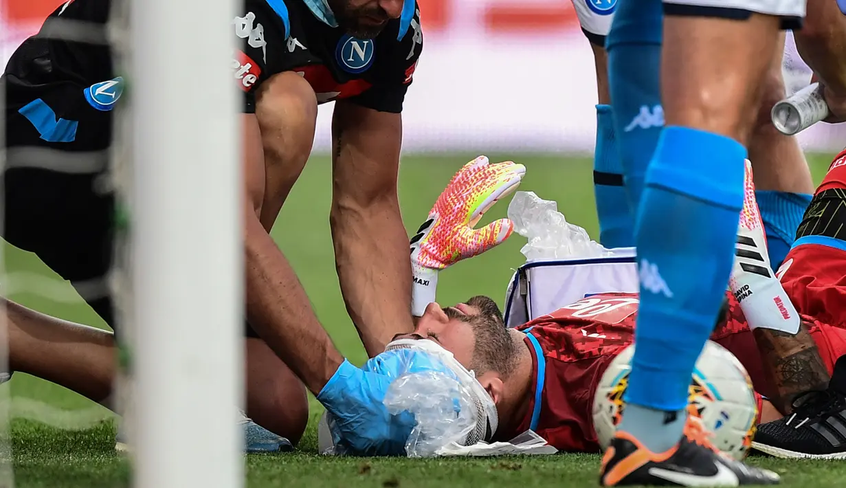 Kiper Napoli, David Ospina, mendapatkan perawatan tim medis ketika mengalami cedera laga Napoli kontra Atalanta pada Jumat (3/7/2020). Ospina yang coba menghalau bola berbenturan dengan Mario Rui dan Mattia Caldara dan mengalami cedera pendarahan di bagian kepala. (AFP/Miguel Medina)