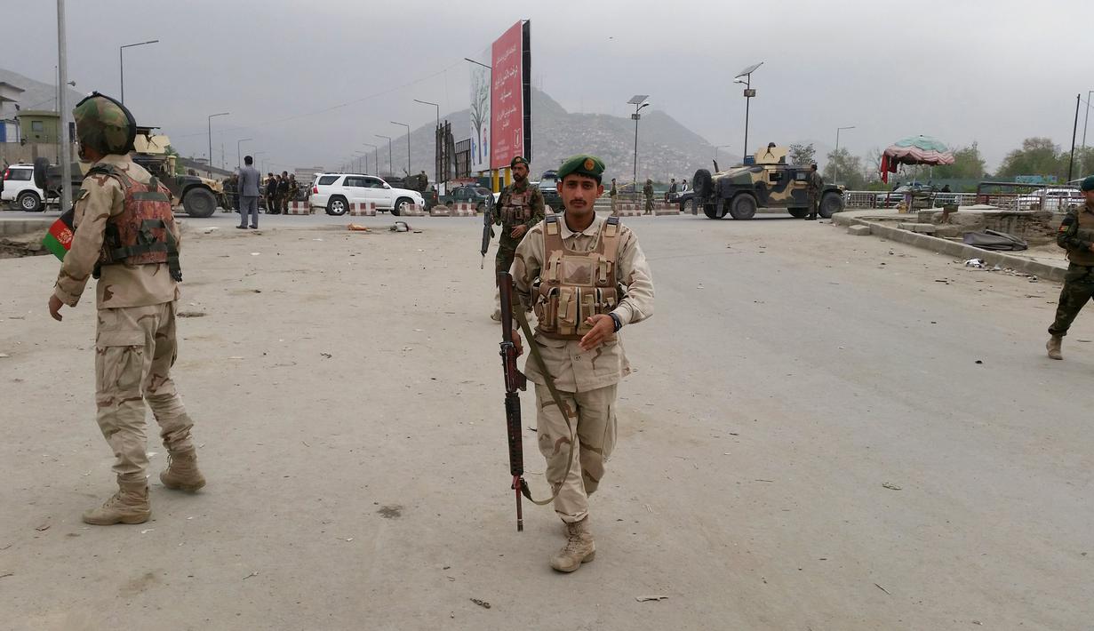 Anggota keamanan berjaga-jaga di lokasi ledakan di Kabul, Afghanistan, Selasa (19/4). Ledakan yang berasal dari sebuah serangan bom bunuh diri itu menyebabkan puluhan orang tewas dan sedikitnya 150 lainnya terluka. (REUTERS/Omar Sobhani)