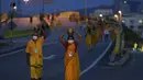 Umat Hindu mengenakan masker membawa teko susu dalam prosesi selama festival Thaipusam sebagai umat mematuhi prosedur operasi standar yang ketat karena pandemi COVID-19 di Gua Batu di pinggiran Kuala Lumpur, Malaysia, Selasa (18/1/2022). (AP Photo/ Vincent Thian)