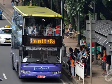 Para wisatawan menunggu bus tingkat wisata atau City Tour Jakarta, Jakarta, Sabtu (10/1/2015). (Liputan6.com/Miftahul Hayat)
