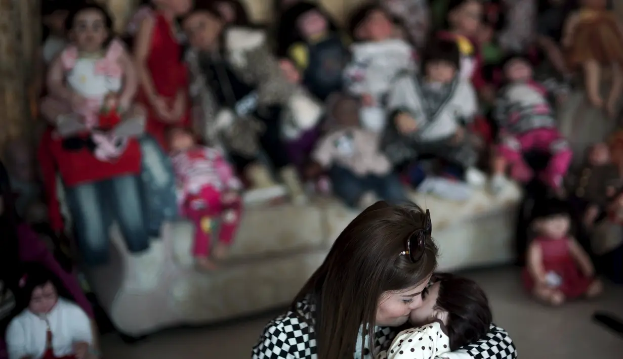 Natsuda Jantabtim (45) mencium boneka Look Thep (anak malaikat) di Nonthaburi, Thailand, Selasa (26/1). Masyarakat Thailand tengah digandrungi boneka yang diisi dengan roh anak kecil melalui ritual tertentu tersebut (REUTERS/Athit Perawongmetha)